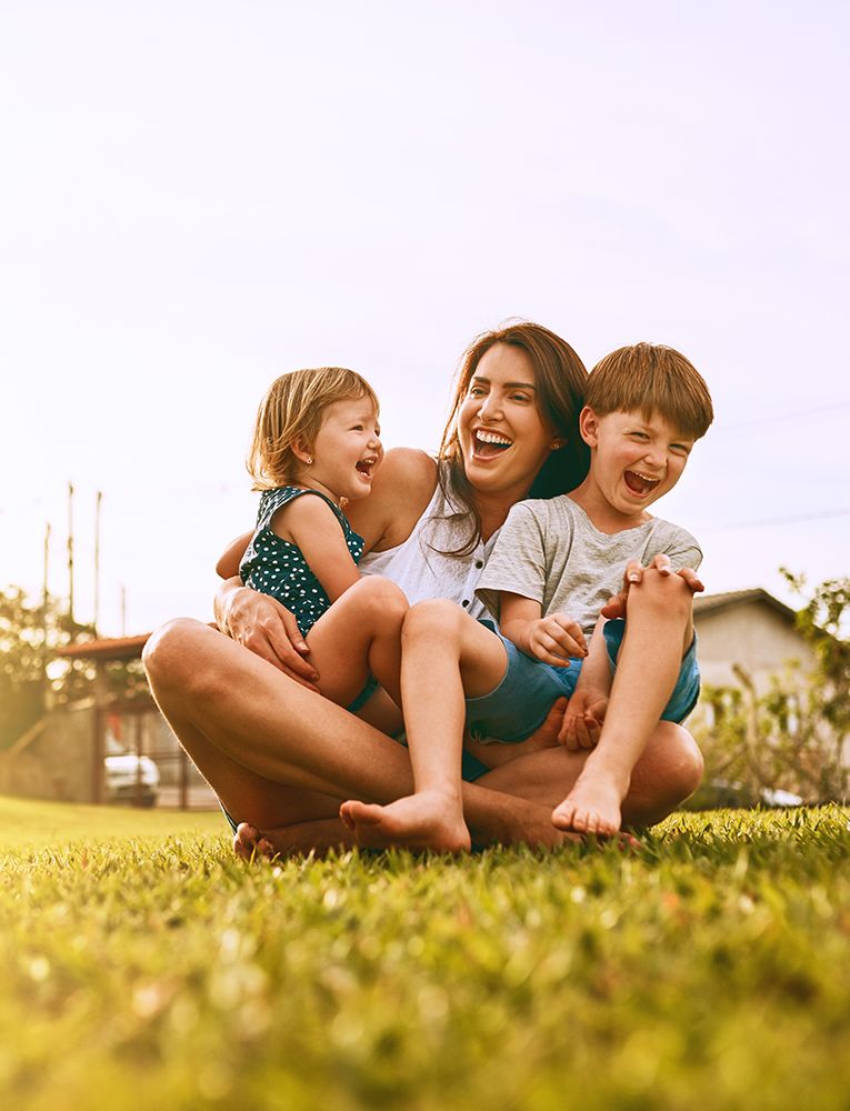 A young family spending time together on their lawn in the summer.