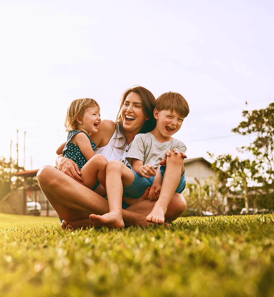 A young family spending time together on their lawn in the summer.